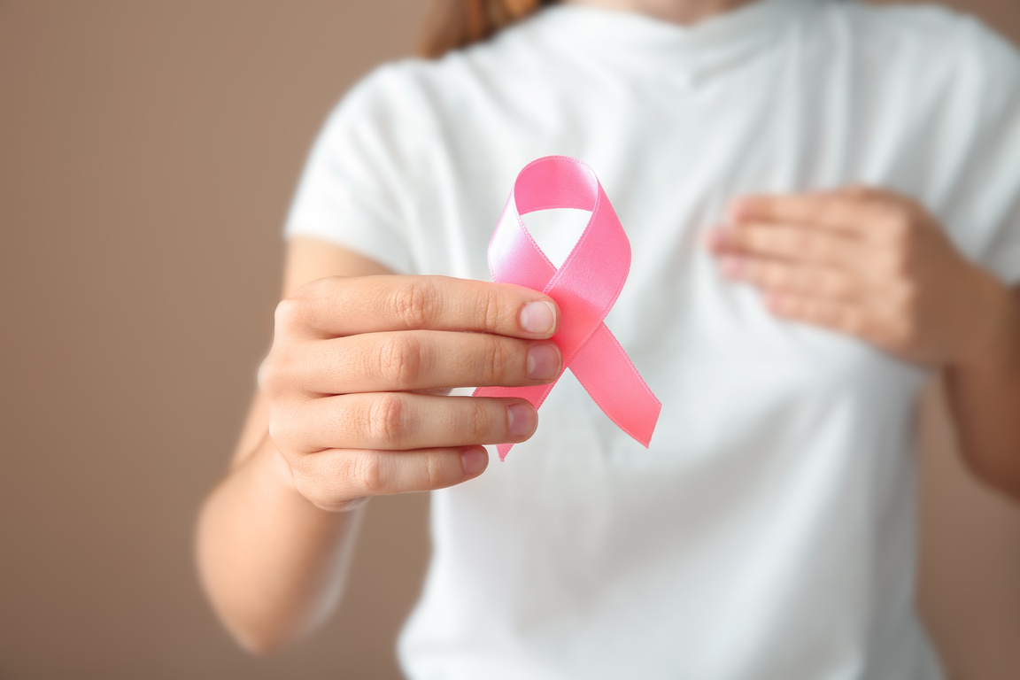 Woman Holding Pink Ribbon, Closeup. Breast Cancer Concept