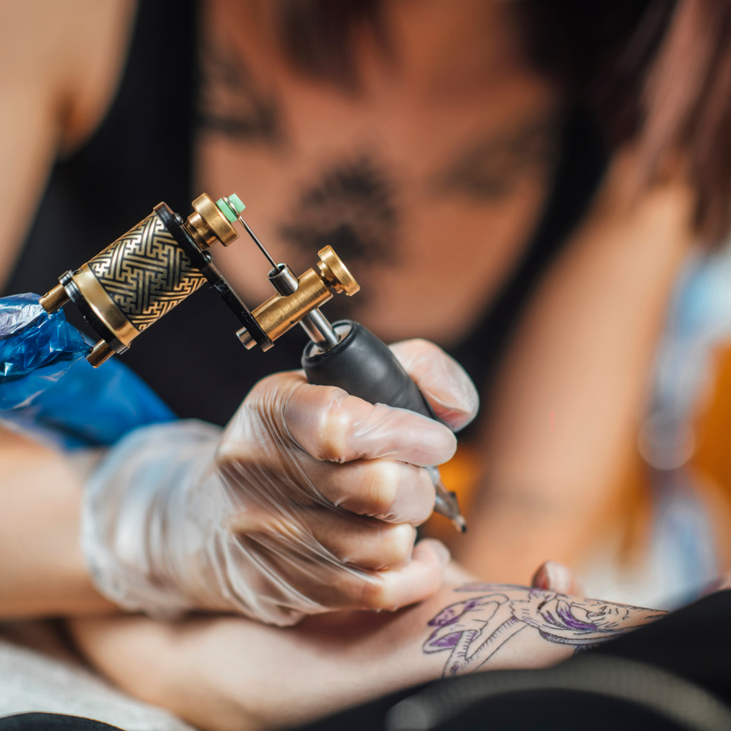 Tattoo Machine Close Up. Tattoo Artist Creating Tattoo On A Man's Arm